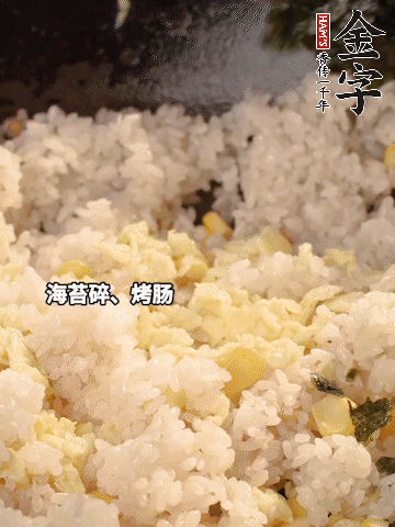 剩米飯下鍋炒散，依次下玉米粒、雞蛋、烤腸、海苔碎翻炒均勻。
