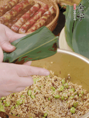 粽葉往下折，完全蓋住，兩側(cè)捏緊。