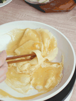 油6成熱時(shí)，下雞蛋液，邊緣凝固時(shí)翻拌成塊狀。