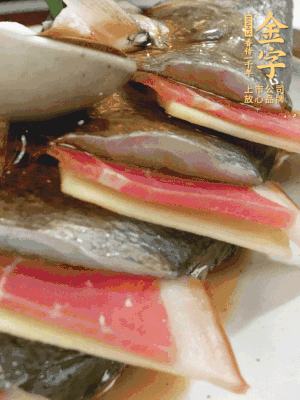 魚肚中塞蔥結(jié)、火腿片，魚身上碼放姜片、火腿片，倒入混合的料汁。
